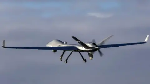 RAF A generic image of a RAF surveillance drone flying in the sky with grey clouds behind it.