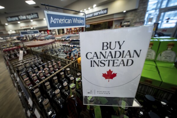 A sign is placed in front of the American whiskey section at a B.C. liquor store after top selling American made products have been removed from shelves in Vancouver, B.C., Sunday, Feb. 2, 2025. (Ethan Cairns/The Canadian Press via AP)