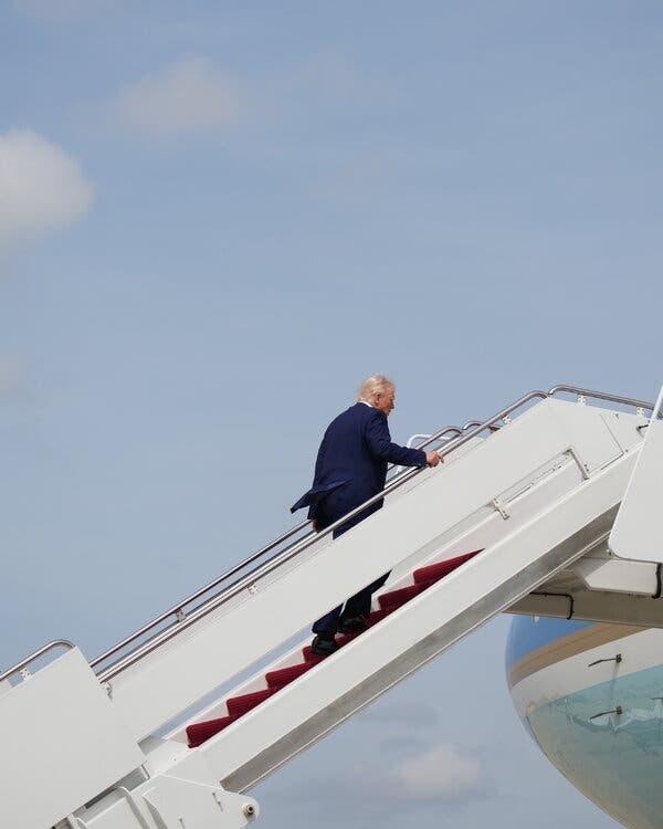 President Trump walks up an airplane gangway.