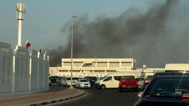 A photograph of smoke in the air behind a white building. 