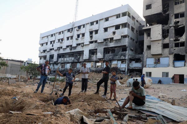 People gather to bury loved ones outside of Al-Shifa hospital in Gaza City.