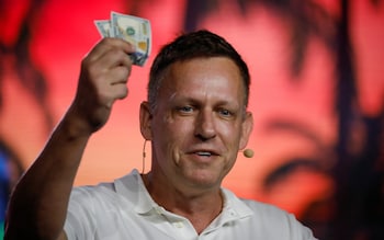 Thiel speaking in public, brandishing cash