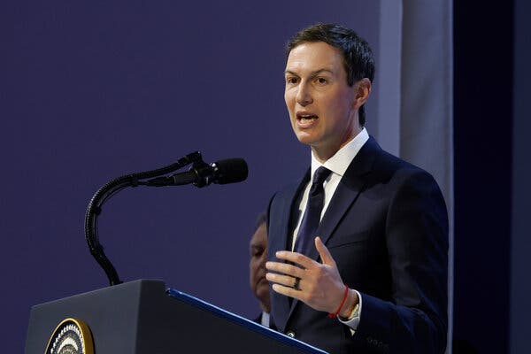 Jared Kushner gestures with his left hand while speaking into a microphone on a lectern.