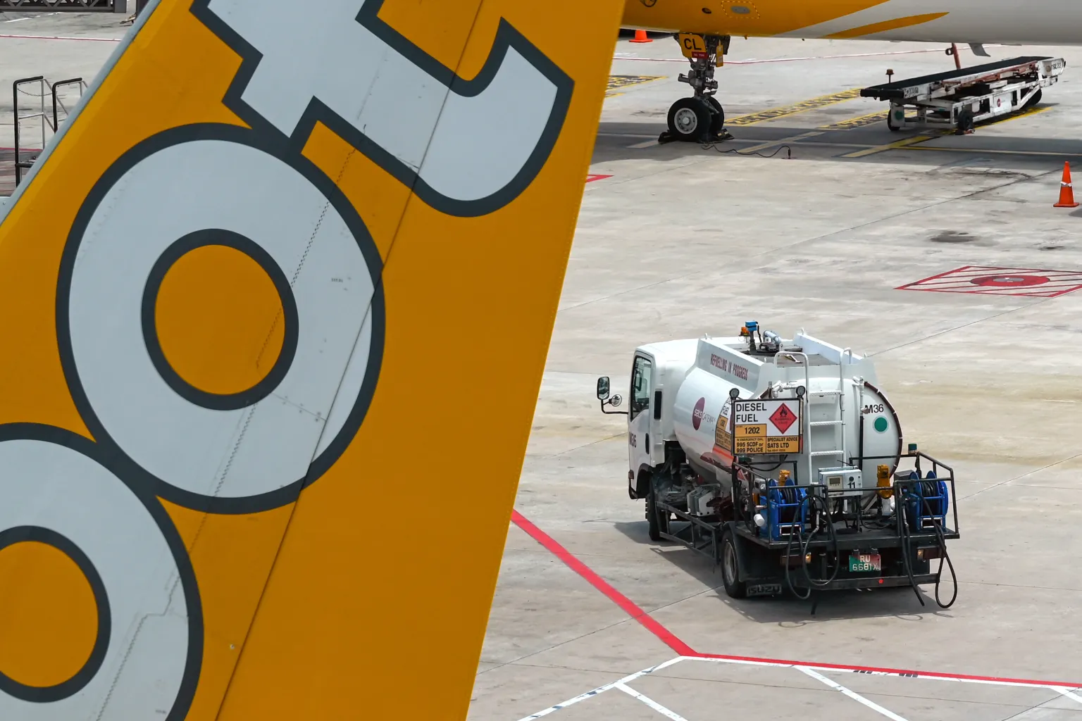 A refueling truck carrying aviation fuel is pictured next to a Scoot passenger jet at Singapore Changi Airport.
