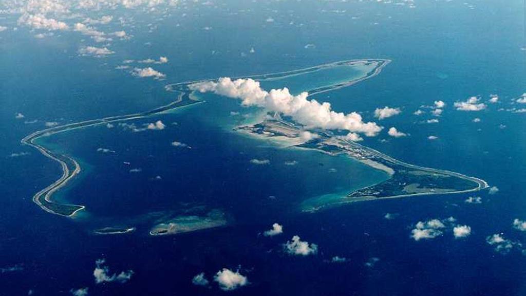 A bird's eye view of the Chagos Islands – officially known as the British Indian Ocean Territory – in the Indian Ocean, with white clouds in the sky. 
