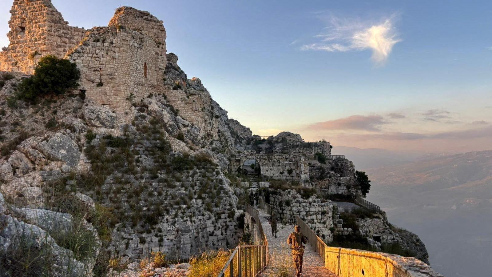 Israeli soldiers walk through the ruins of Beaufort Castle, whose keep stands high above them in the left of the picture.