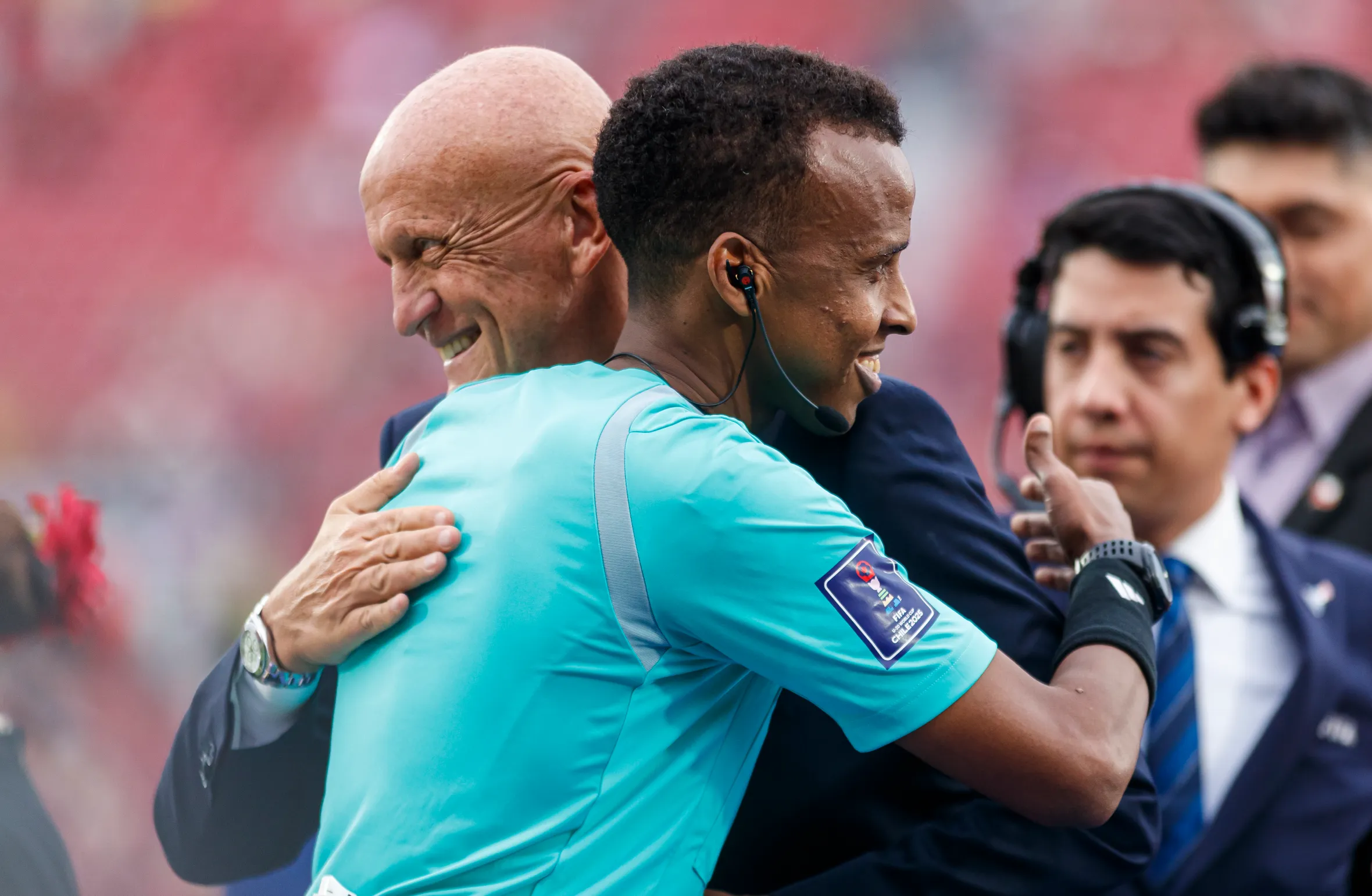 Pierluigi Collina hugs Referee Omar Artan as he receives a medal.