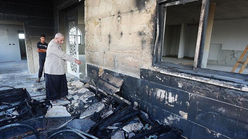 A Palestinian man inspects the damage at a mosque, which Palestinians say was damaged by Israeli settlers, in Qusra near Nablus, in the Israeli-occupied West Bank, July 26, 2026.