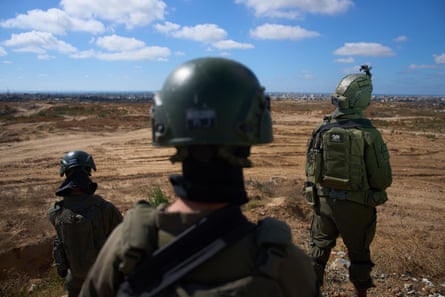 Three Israeli soldiers facing away from camera