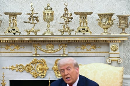 Donald Trump sits beneath a White House mantelpiece filled with gold urns and statuettes