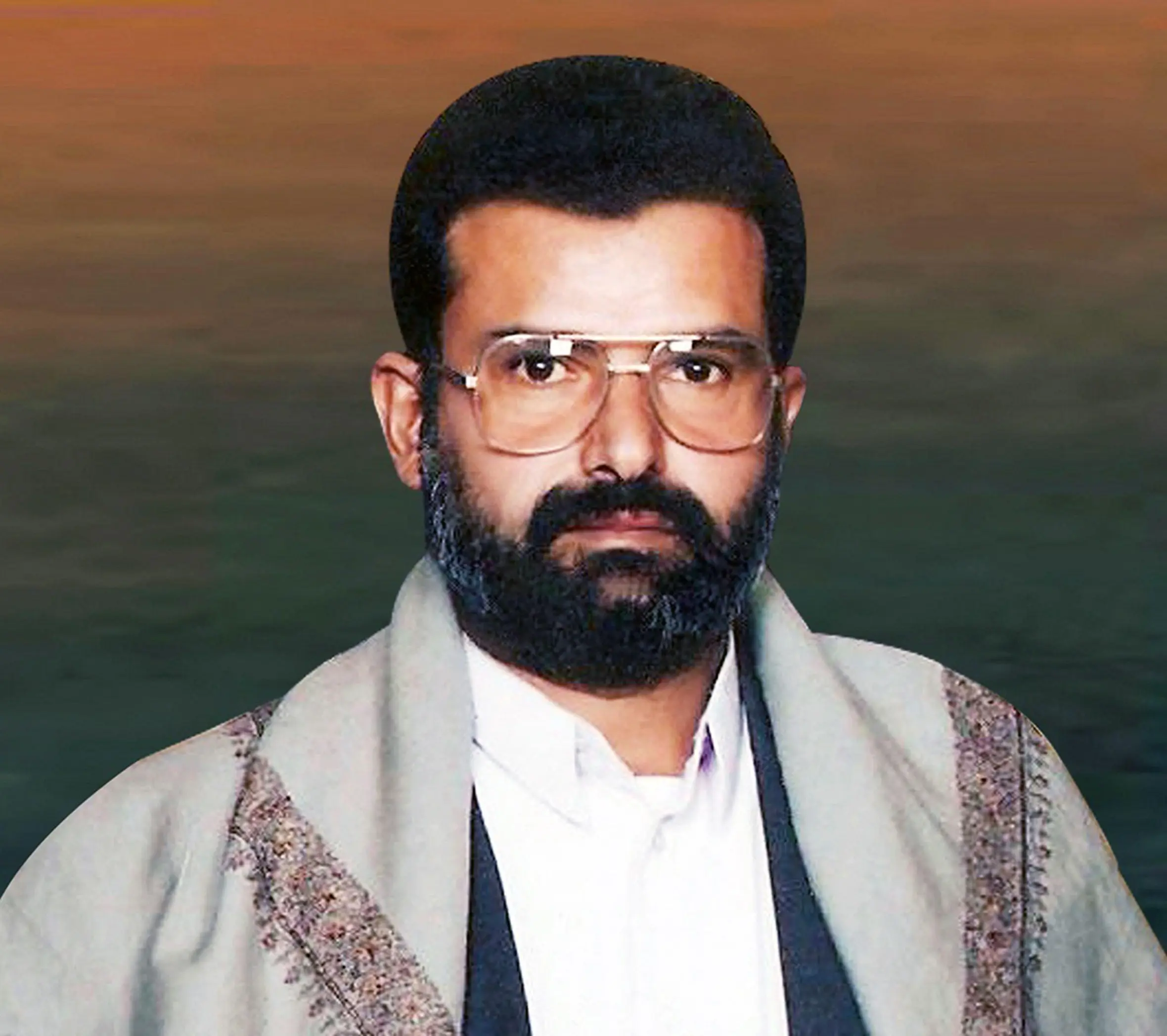 Portrait of Hussein Badreddin al-Houthi with a beard and glasses.