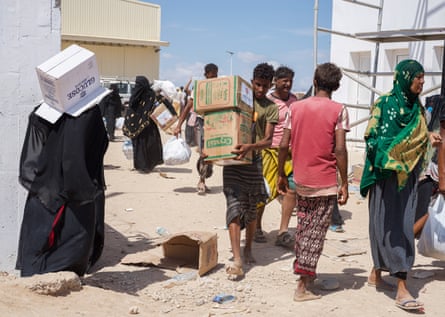 Yemeni refugees carry aid from a government warehouse in Obock, Djibouti.